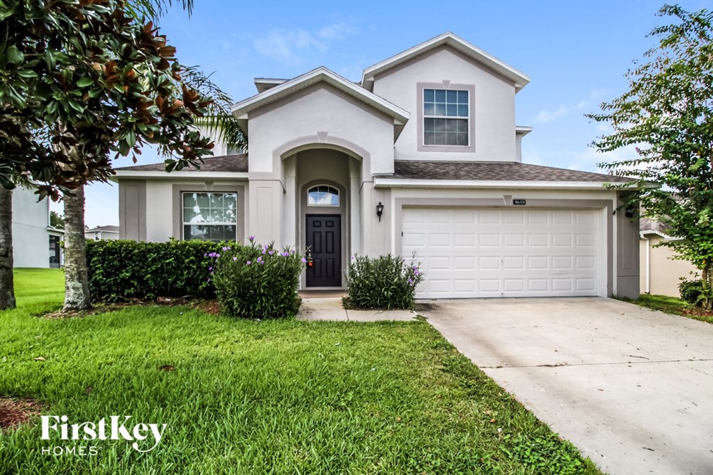 a white house with a driveway and a garage door