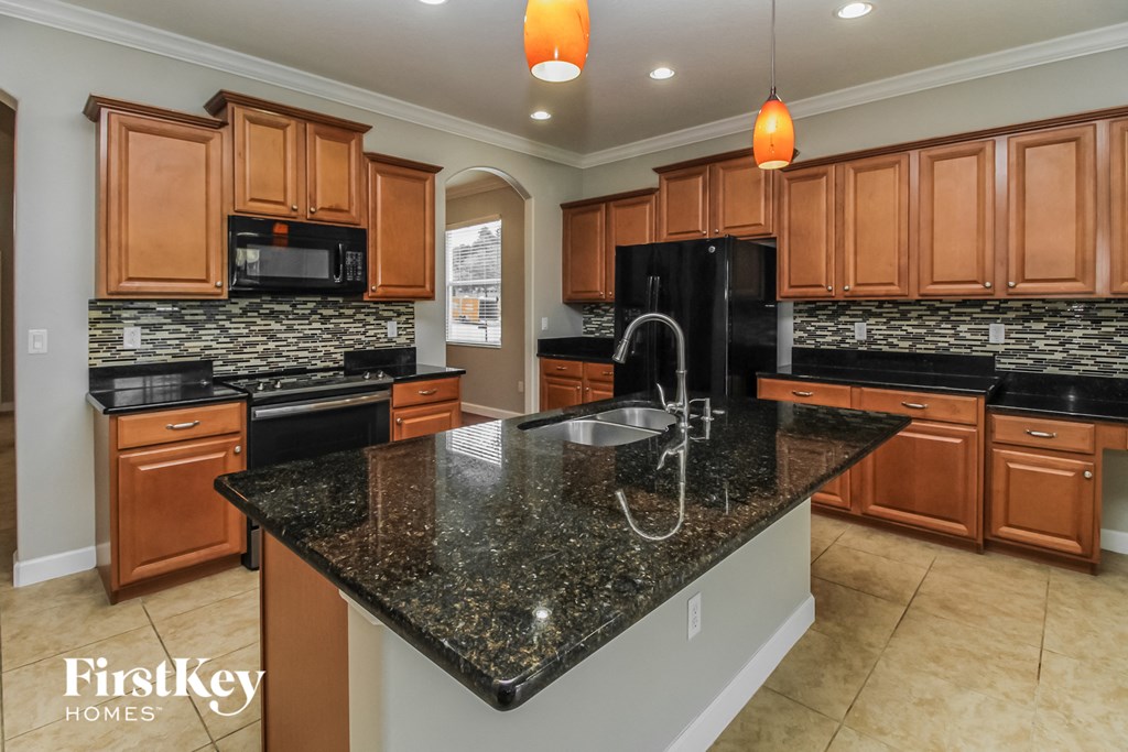 a kitchen with granite counter tops and wooden cabinets