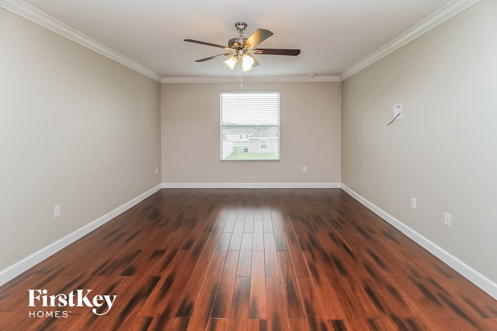 the living room with hardwood flooring and a ceiling fan