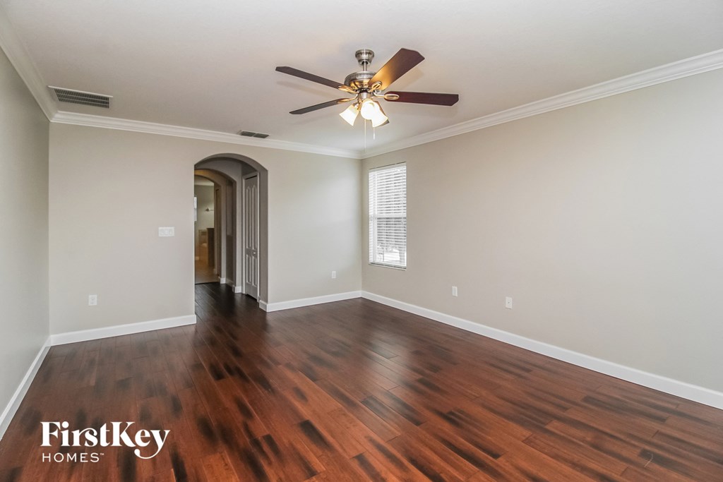 the living room with hardwood flooring and a ceiling fan