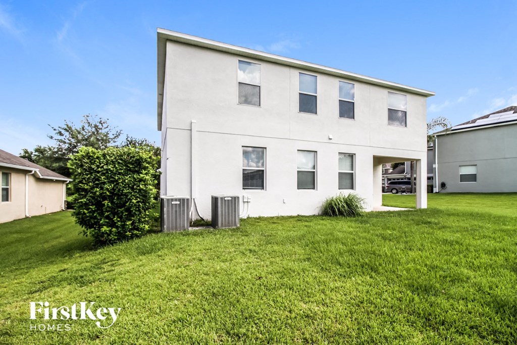 a white house with a green lawn and a blue sky
