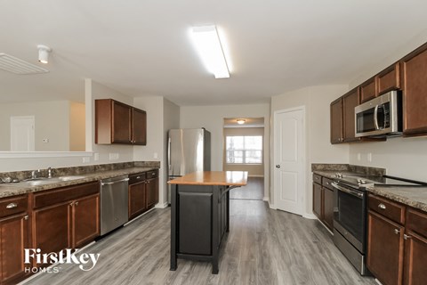 A kitchen with wooden cabinets and a black fridge.