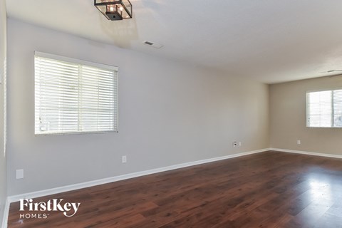 the living room with wood floors and a large window
