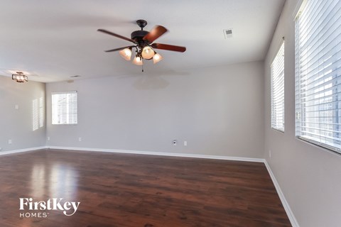 the living room with wood floors and a ceiling fan