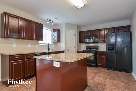 a kitchen with black appliances and a granite counter top