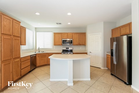 A kitchen with wooden cabinets and a white island.