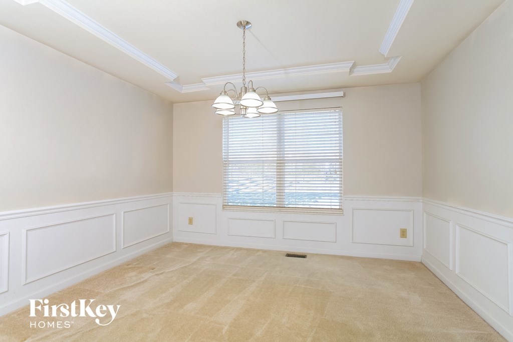 A room with a window and a chandelier.