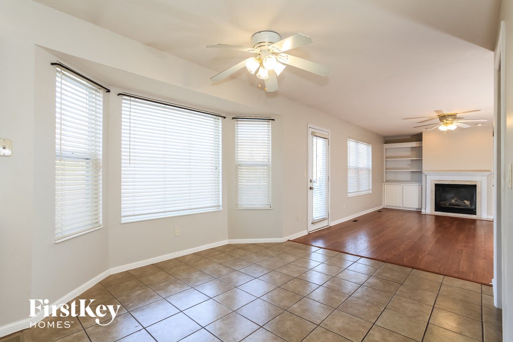 A spacious room with a fireplace and a ceiling fan.