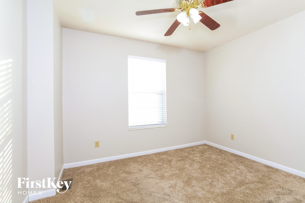 A room with a ceiling fan and a window.