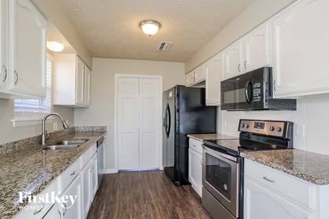 a kitchen with white cabinets and black appliances