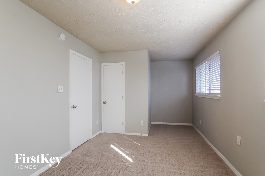 an empty room with a door and a window