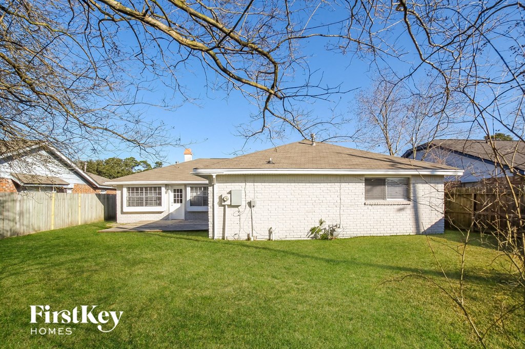a small white house with a yard and a fence