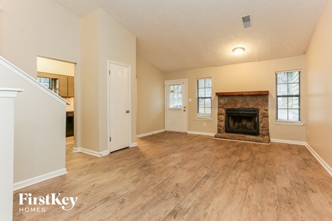 the living room has a fireplace and hardwood floors