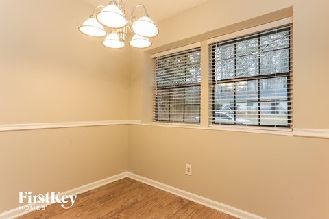 a bedroom with three windows and a wooden floor
