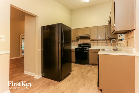 a kitchen with stainless steel appliances and a black refrigerator