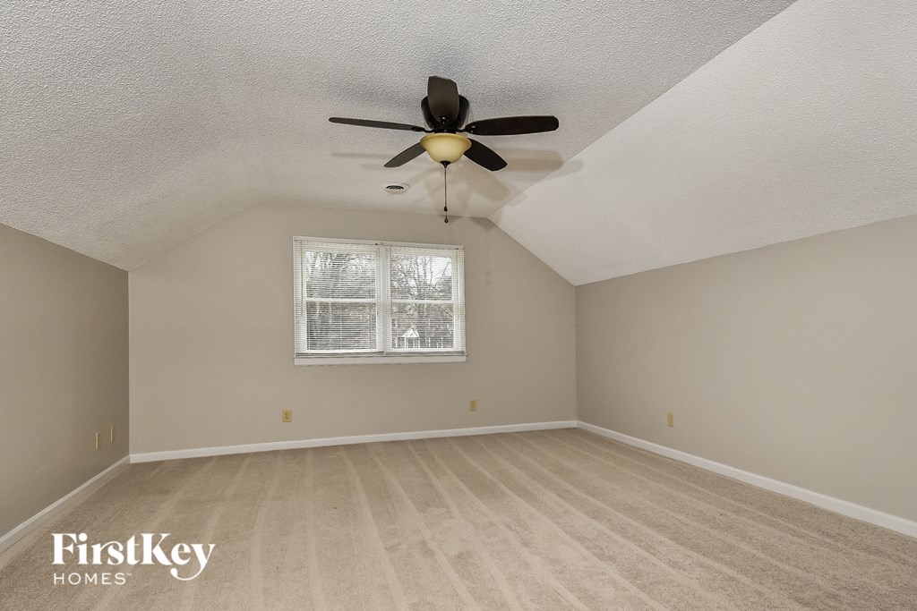 a bedroom with a ceiling fan and a window