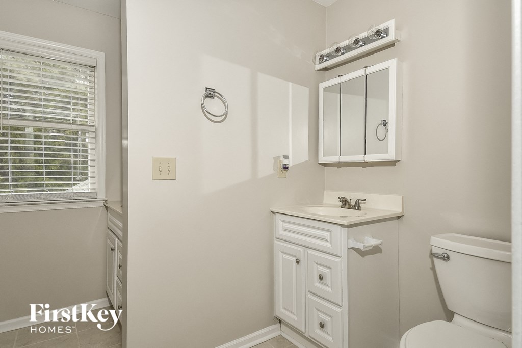a bathroom with a toilet and a sink and a mirror