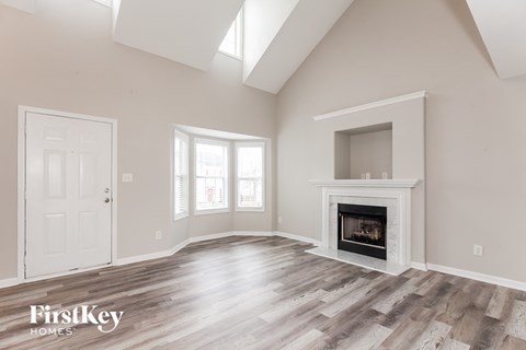 A spacious room with a fireplace and a door on the left side.