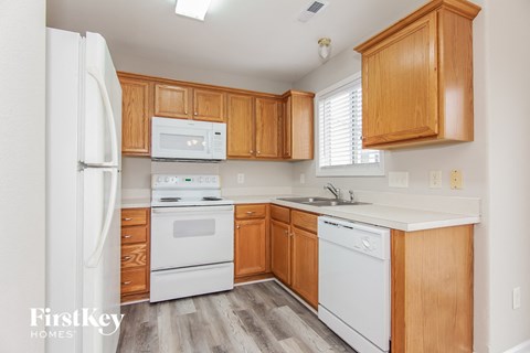 A kitchen with wooden cabinets and white appliances.