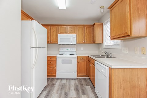 A kitchen with wooden cabinets and white appliances.