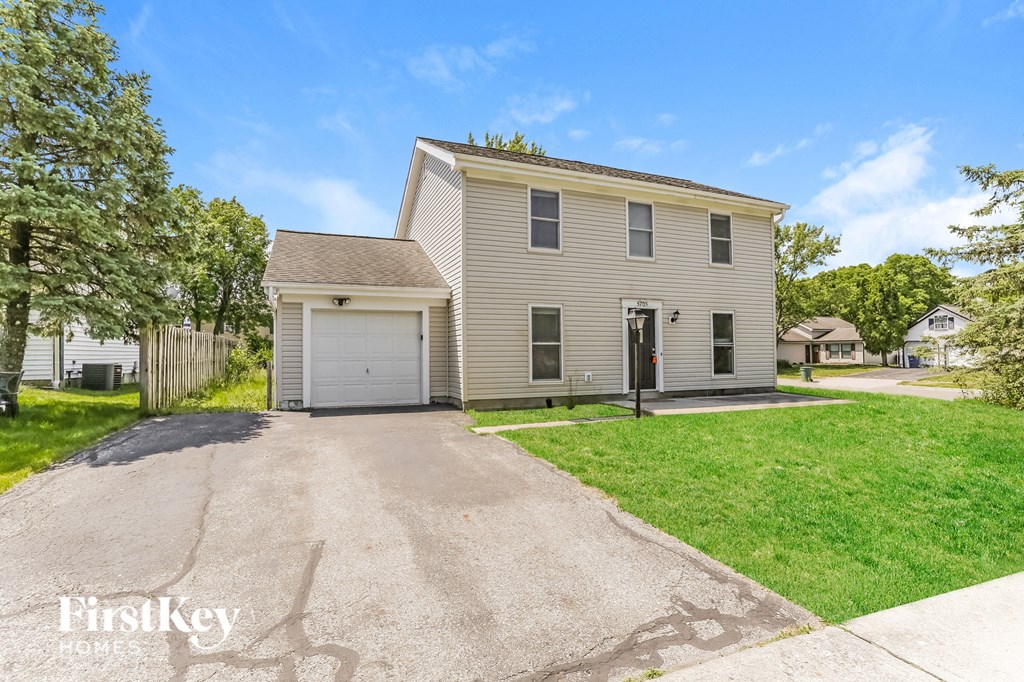 a beige house with a garage and a driveway