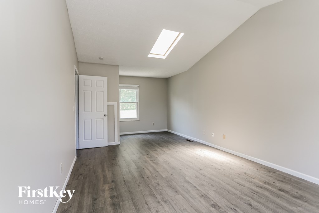 an empty living room with wood floors and white walls