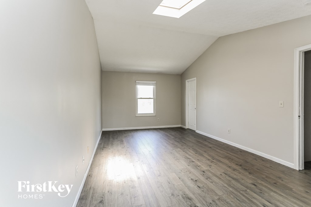 the living room of an empty house with wooden floors and a window
