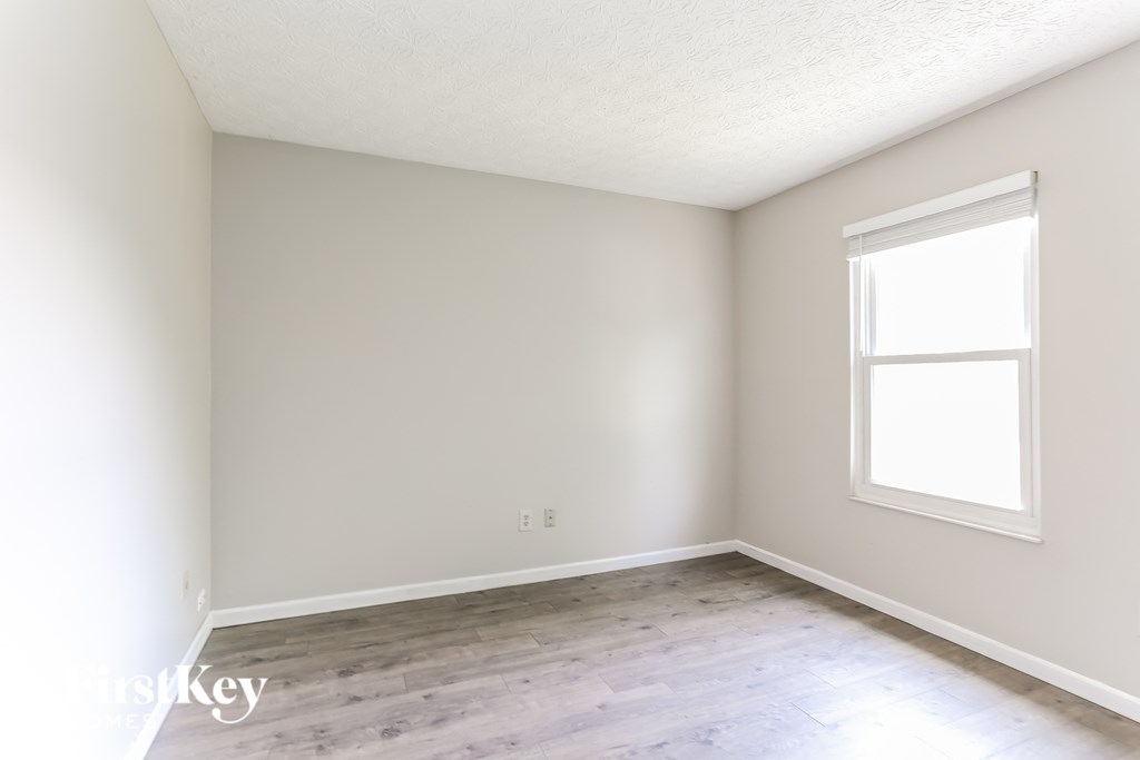 a white room with wood floors and a window