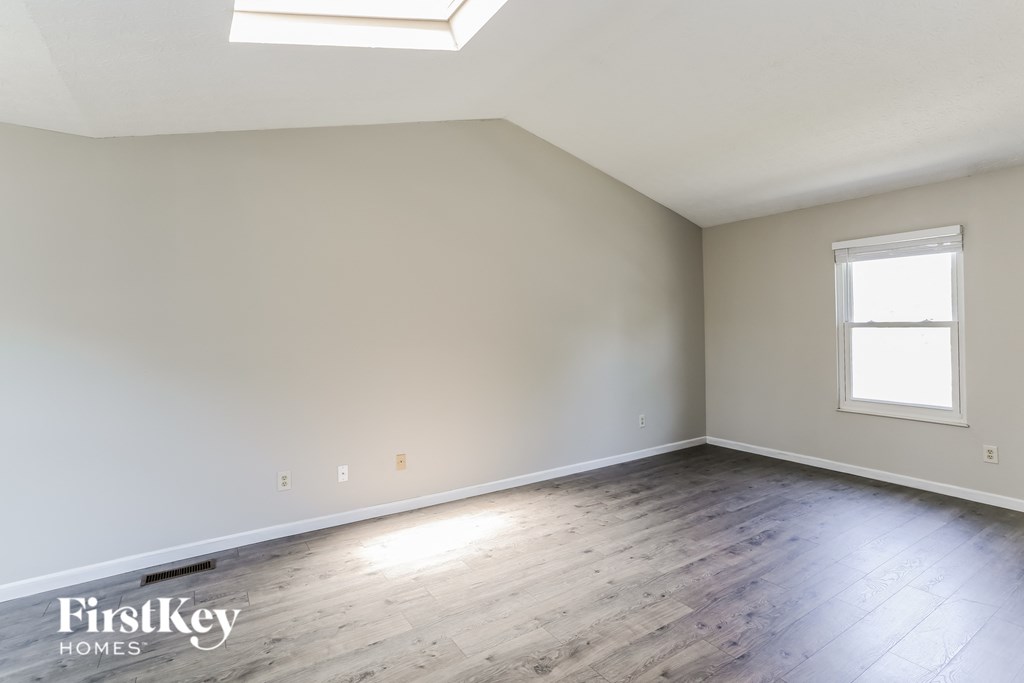 the living room of a home with wood floors and white walls
