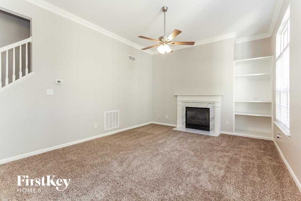 a living room with a fireplace and a ceiling fan