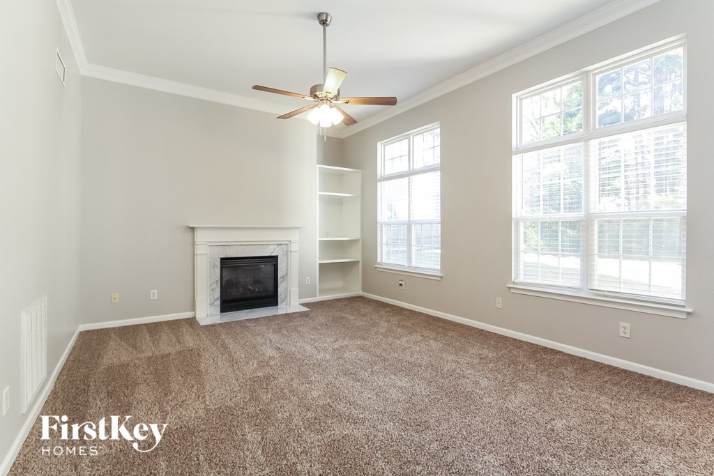 a living room with a fireplace and a ceiling fan