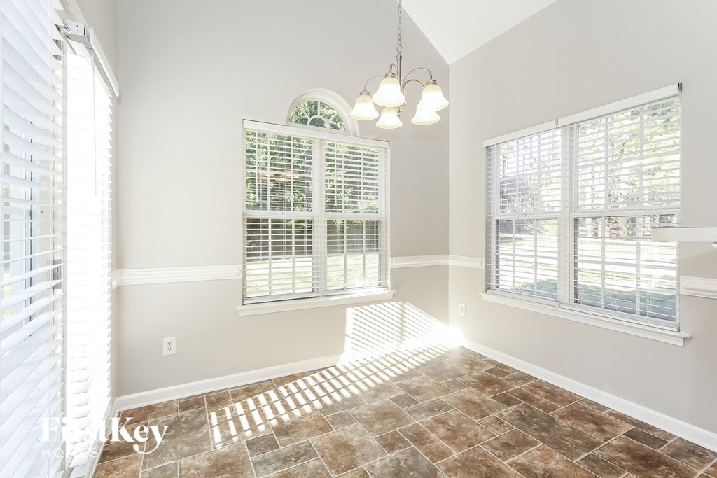 a living room with a large window and a tiled floor