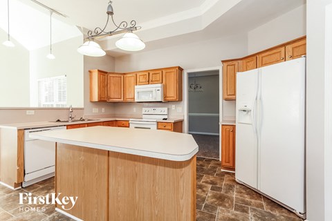 a kitchen with wooden cabinets and a white counter top