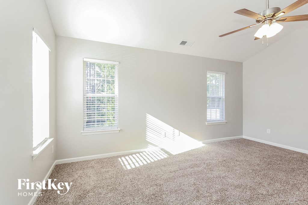 a living room with carpet and a ceiling fan