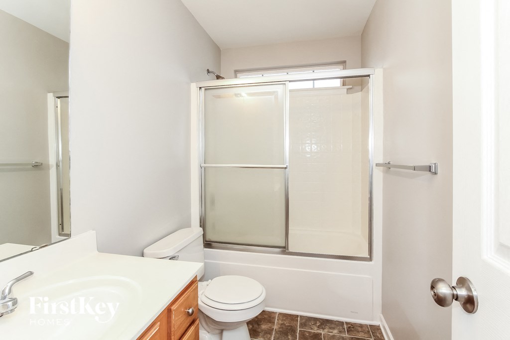 a bathroom with a shower and a sink and a toilet