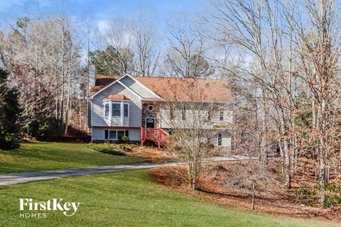 a blue house with a lawn and trees