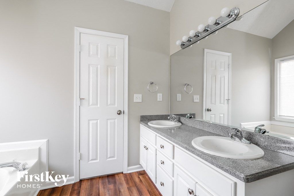 a white bathroom with two sinks and a mirror