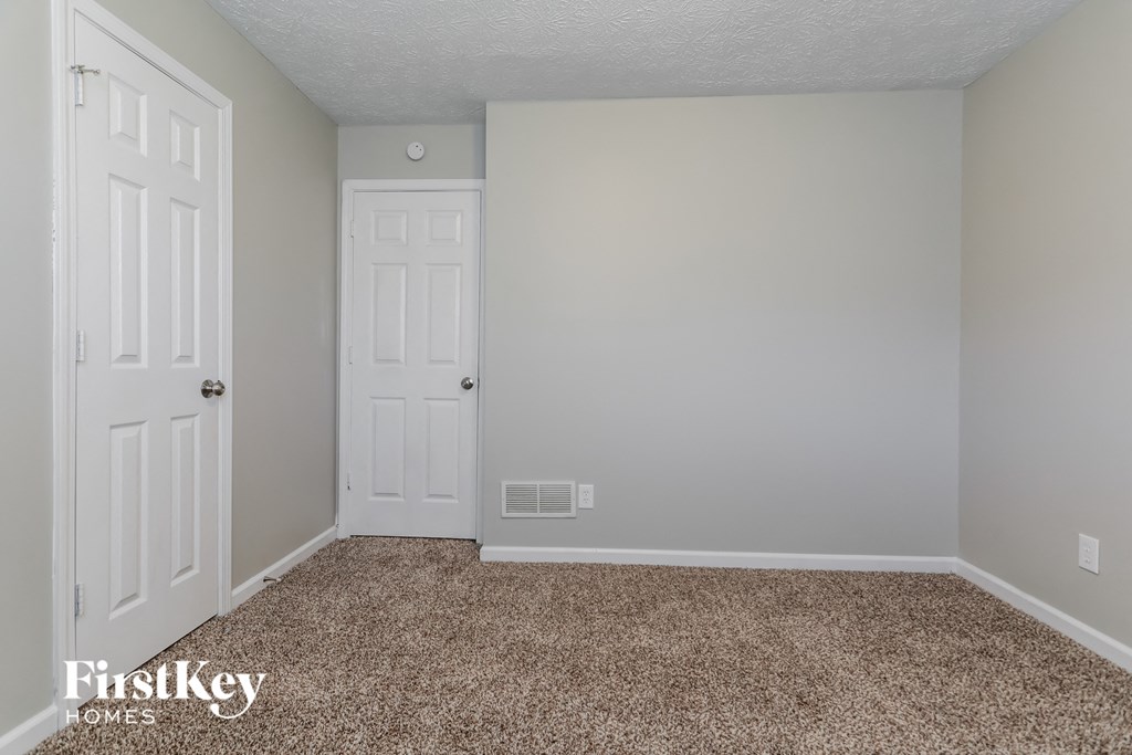 a bedroom with a carpeted floor and white doors