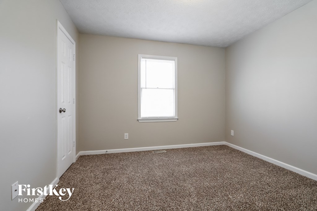 a empty room with carpet and a window