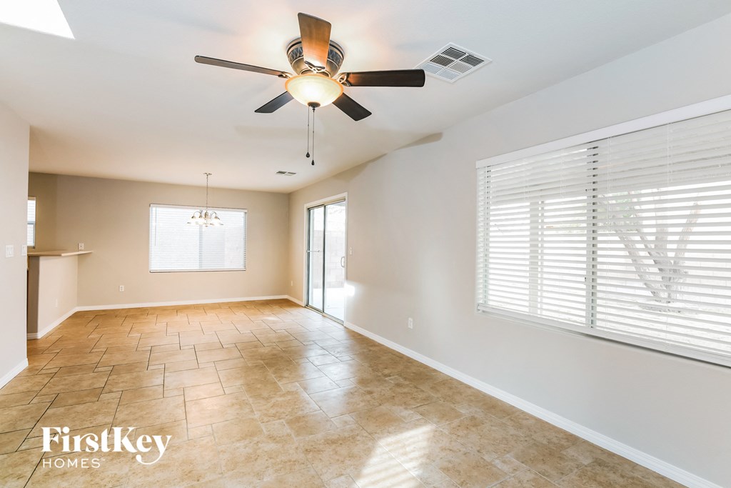 A spacious room with a ceiling fan and tiled flooring.
