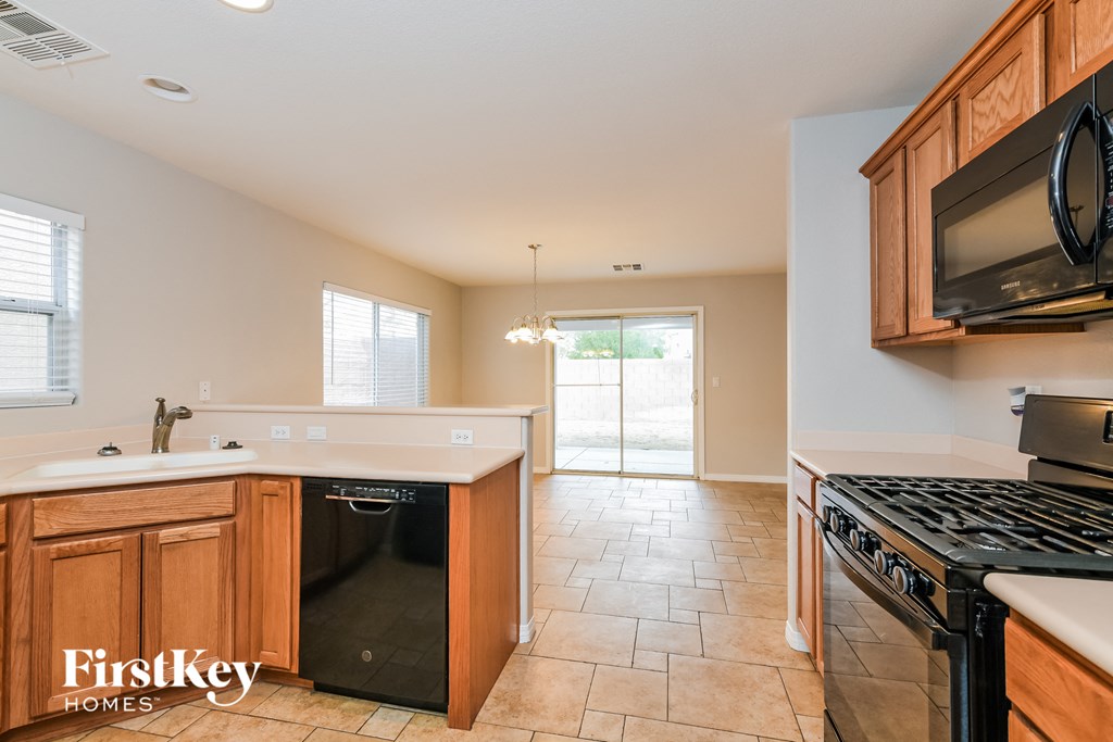 A kitchen with a black dishwasher and stove top oven.