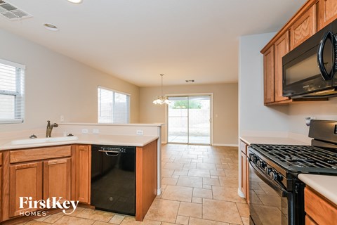 A kitchen with a black dishwasher and stove top oven.