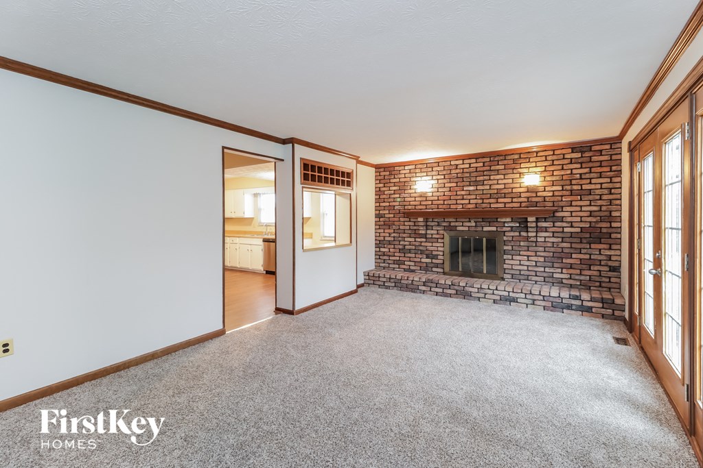a living room with a brick fireplace and a white wall