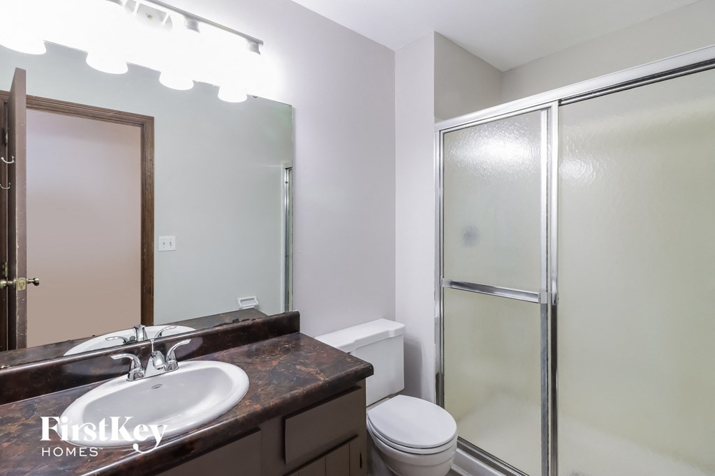 a bathroom with a sink and a shower and a toilet