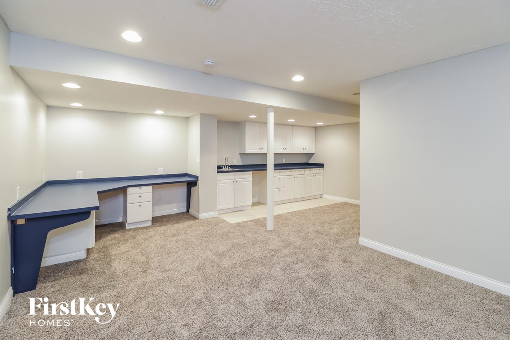 a bonus room with a desk and a kitchen