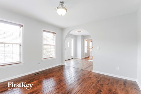 an empty living room and dining room with wood floors