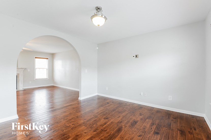 an empty living room with white walls and wood floors