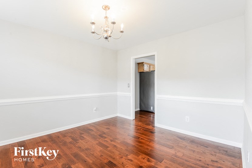 an empty living room with wood flooring and white walls