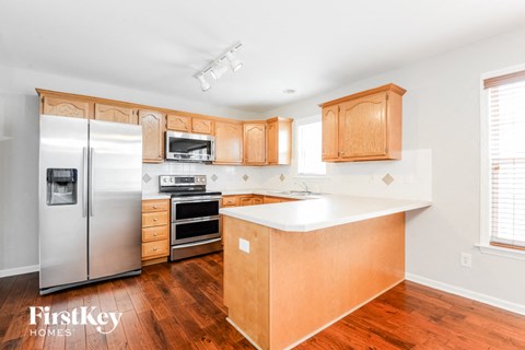 a kitchen with wooden cabinets and a stainless steel refrigerator