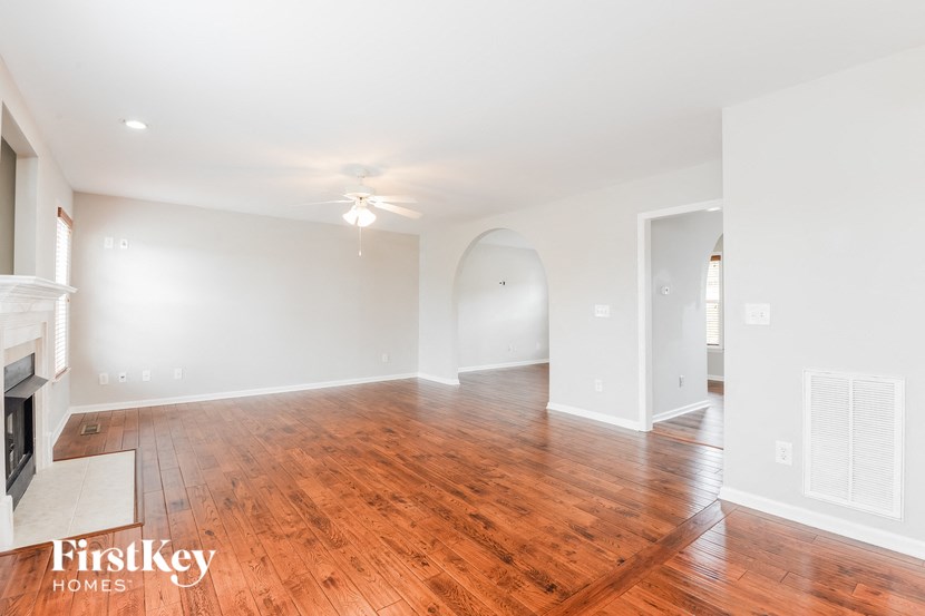 an empty living room with wood flooring and a fireplace
